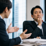 決断を求める部下の話を聞きながら考え込む上司