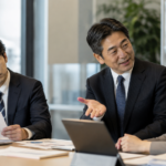 上司が話しやすい部下を評価する一方で、納得できない表情を見せる別の部下