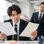 昨日と今日で変わる上司の指示に困惑し、書類を見比べる部下