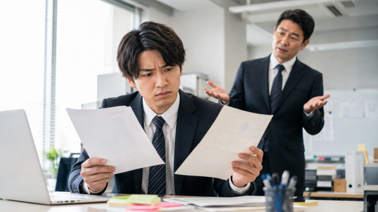 昨日と今日で変わる上司の指示に困惑し、書類を見比べる部下