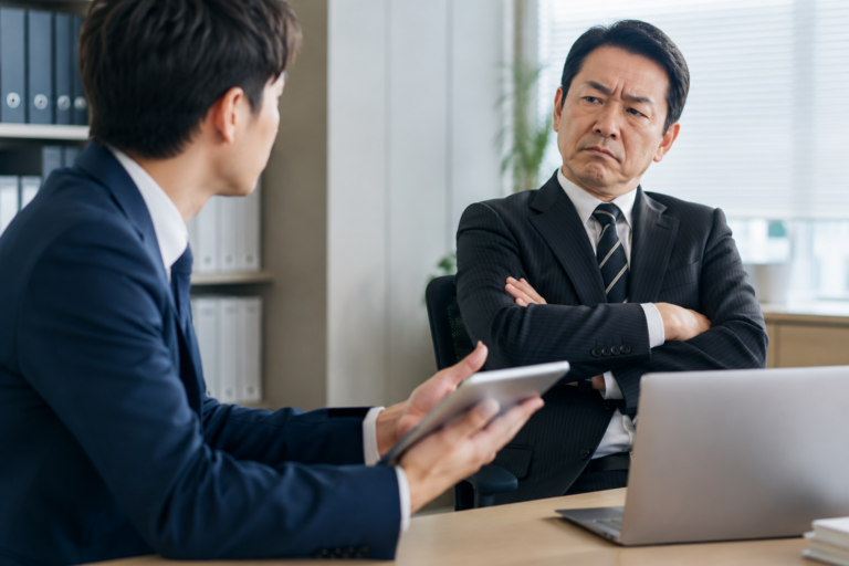 新しい仕事のやり方を提案する部下に、腕を組んで難色を示す上司