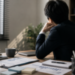 仕事を一人で抱え込み、周囲に相談できず悩む会社員