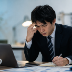 仕事のミスに気づき、報告する前に自分で対応しようと悩む会社員