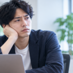 転職後の職場で、前の会社と同じ悩みを繰り返していることに気づき考え込む男性