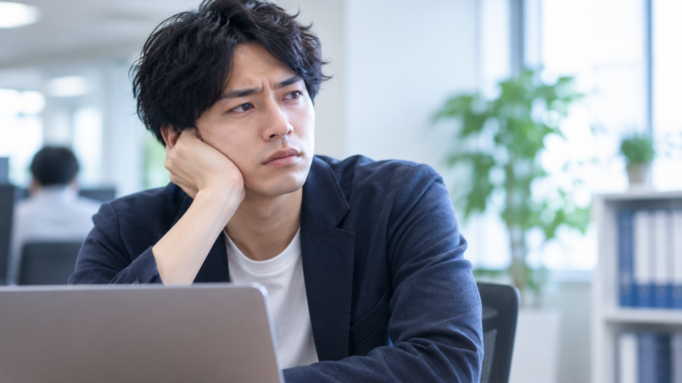 転職後の職場で、前の会社と同じ悩みを繰り返していることに気づき考え込む男性